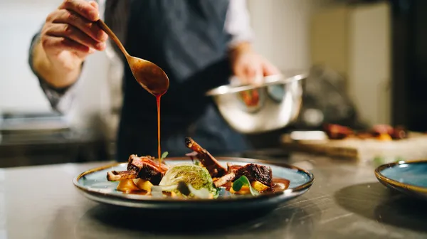1766132591-chef-pouring-special-sauce-pork-ribs-kitchen (3)